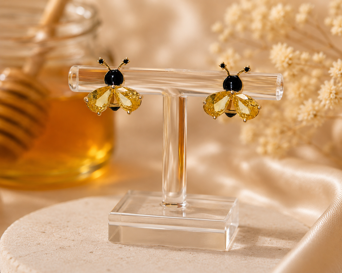 VIYOMA Honeybee Crystal Studs with faceted yellow crystal wings and black enamel details displayed on a clear jewelry stand