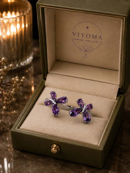 VIYOMA Butterfly Rift Ring presented in a premium olive-green jewelry box with soft champagne interior, showcasing its adjustable open-band design and violet crystal butterfly motifs.