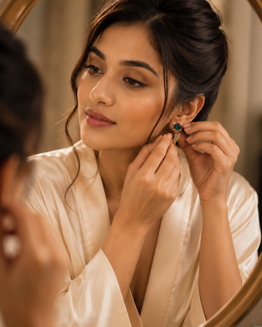Model wearing the VIYOMA Sapphire Fox Tail Earrings while adjusting the earring in front of a mirror, highlighting the elegant fox-tail design.