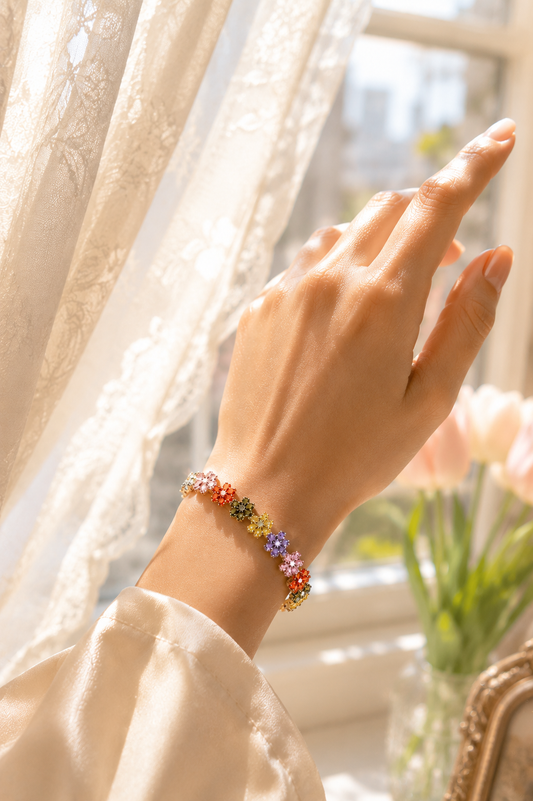 Model wearing the VIYOMA Enchanted Garden Bracelet near a sunlit window, showcasing colorful floral crystal details and elegant styling.